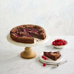 Slice of dark chocolate and raspberry indulgence cake showing moist flourless texture with fresh raspberries Bakealicious Sydney