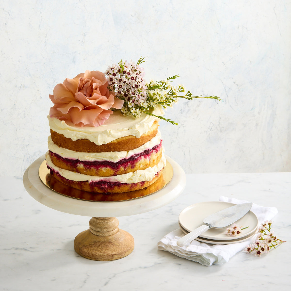 Gluten-free naked Victoria sponge cake with fresh flowers, cream and raspberry layers Bakealicious Sydney