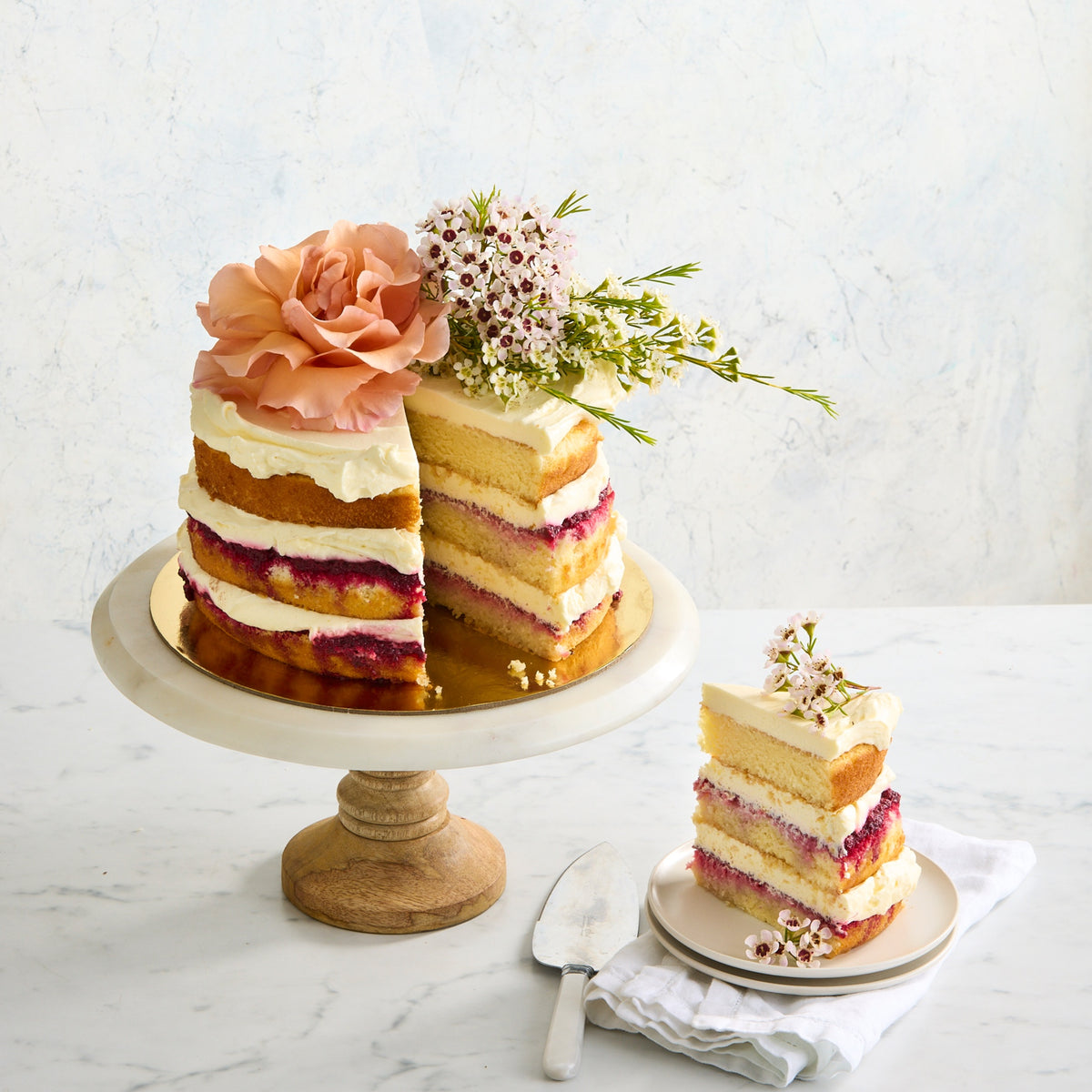 Slice of naked Victoria sponge cake showing fluffy layers with cream and raspberry filling Bakealicious Sydney