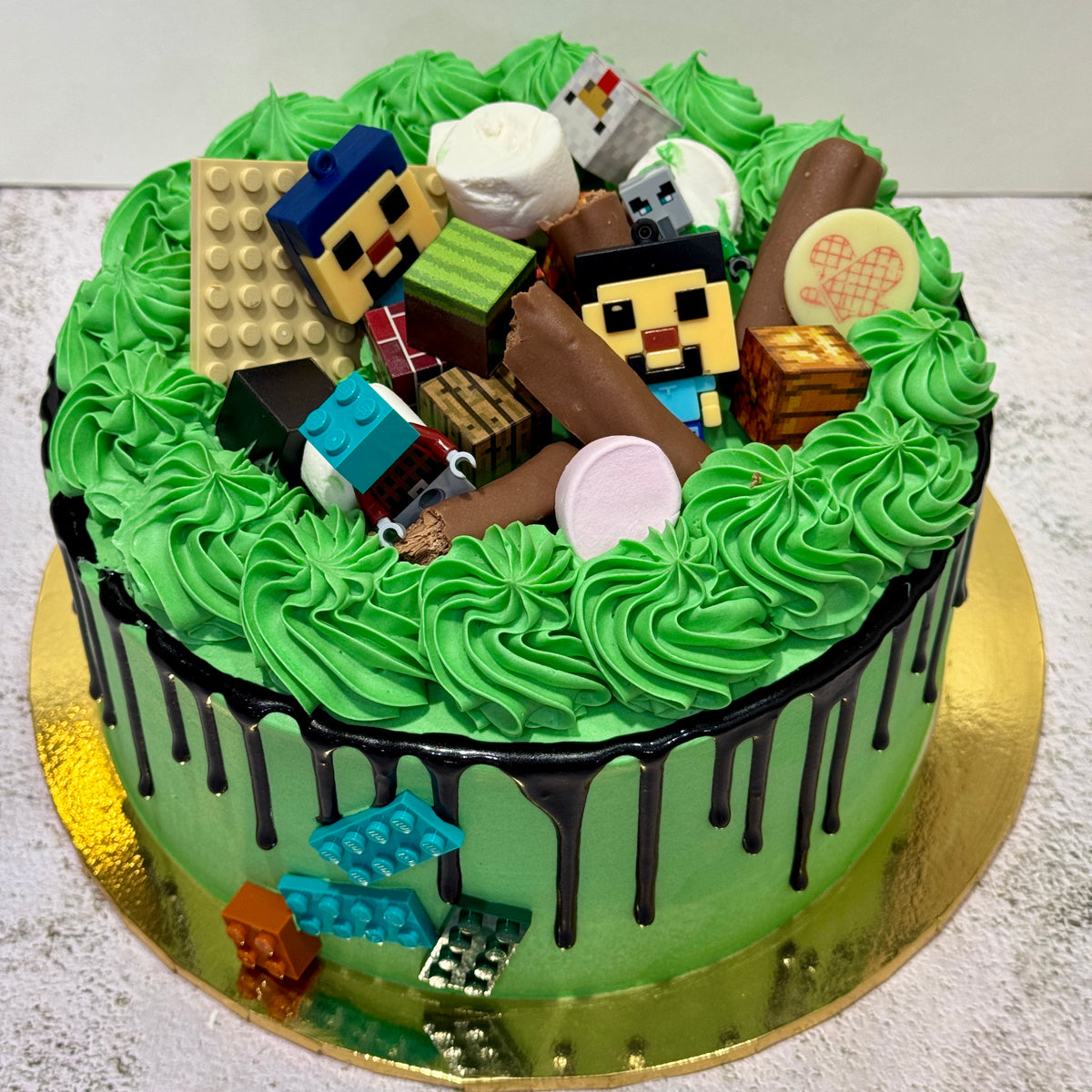 Minecraft birthday cake with green buttercream, chocolate drip and edible themed decorations