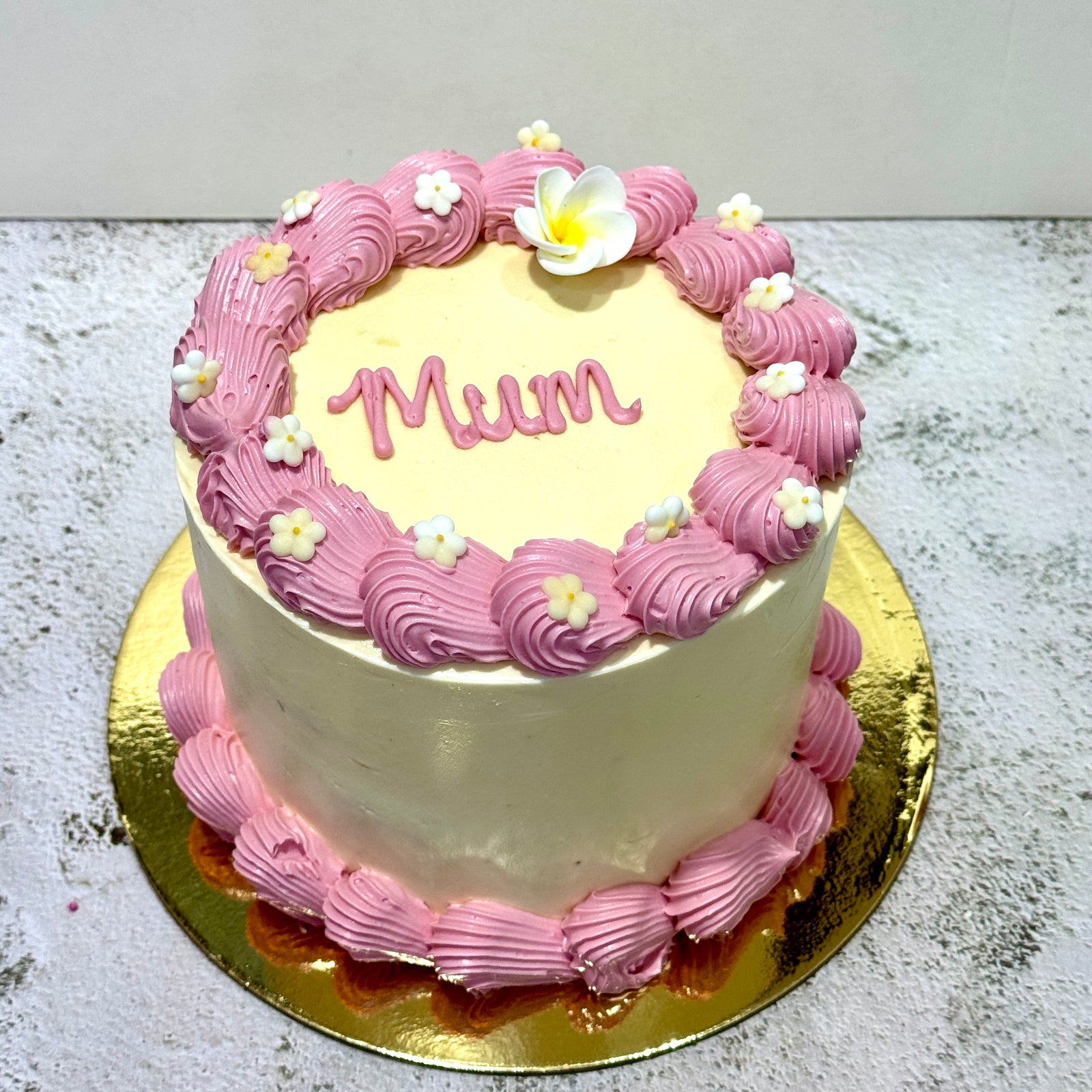 Round Mother’s Day cake with pink piping and Mum message