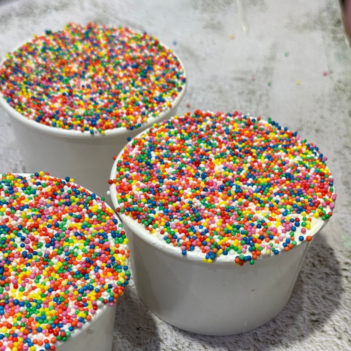 Colourful Dot Cake covered in rainbow hundreds and thousands by Bakealicious Sydney.