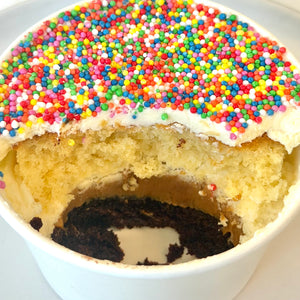 Dot Cake showing layers of vanilla sponge, dulce de leche, chocolate sponge and vanilla buttercream topped with colourful hundreds and thousands