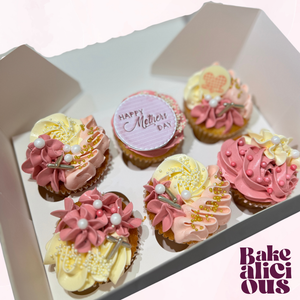 Decorative cupcakes in a box with 'Happy Mother's Day' message, featuring pink and yellow frosting.